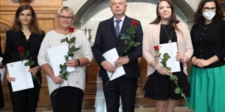 Powiększ grafikę: Na zdjęciu stoją laureaci Nagrody Prezydenta Gdańska, wszyscy trzymają w rękach dokument uznania i czerwoną różę. Od lewej strony nasza nauczycielka Kinga Bulińska, oraz troje pozostałych nagrodzonych nauczycieli z innych szkół. Po prawej stronie stoi Prezydent Gdańska Aleksandra Dulkiewicz