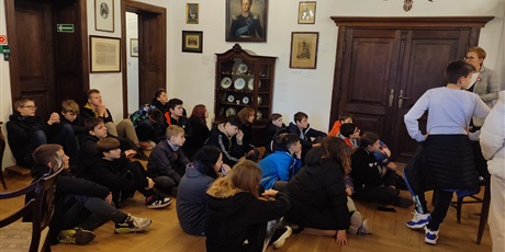 Powiększ grafikę: Uczniowie siedzą w sali i słuchają przewodnika